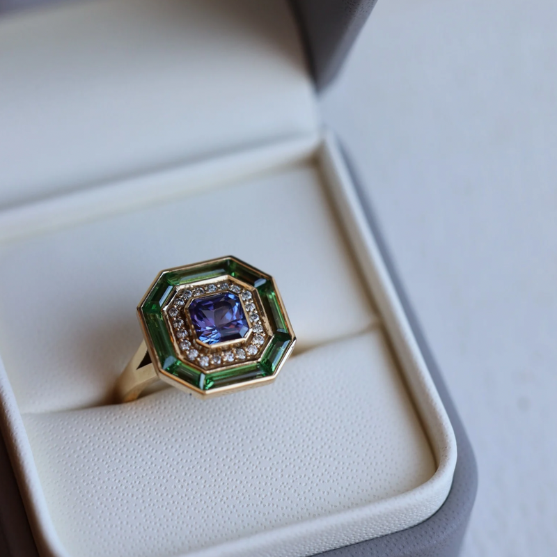 Exquisite 1.15ct Tanzanite ring in 18k yellow gold, surrounded by diamonds and green tsavorites, UK size M